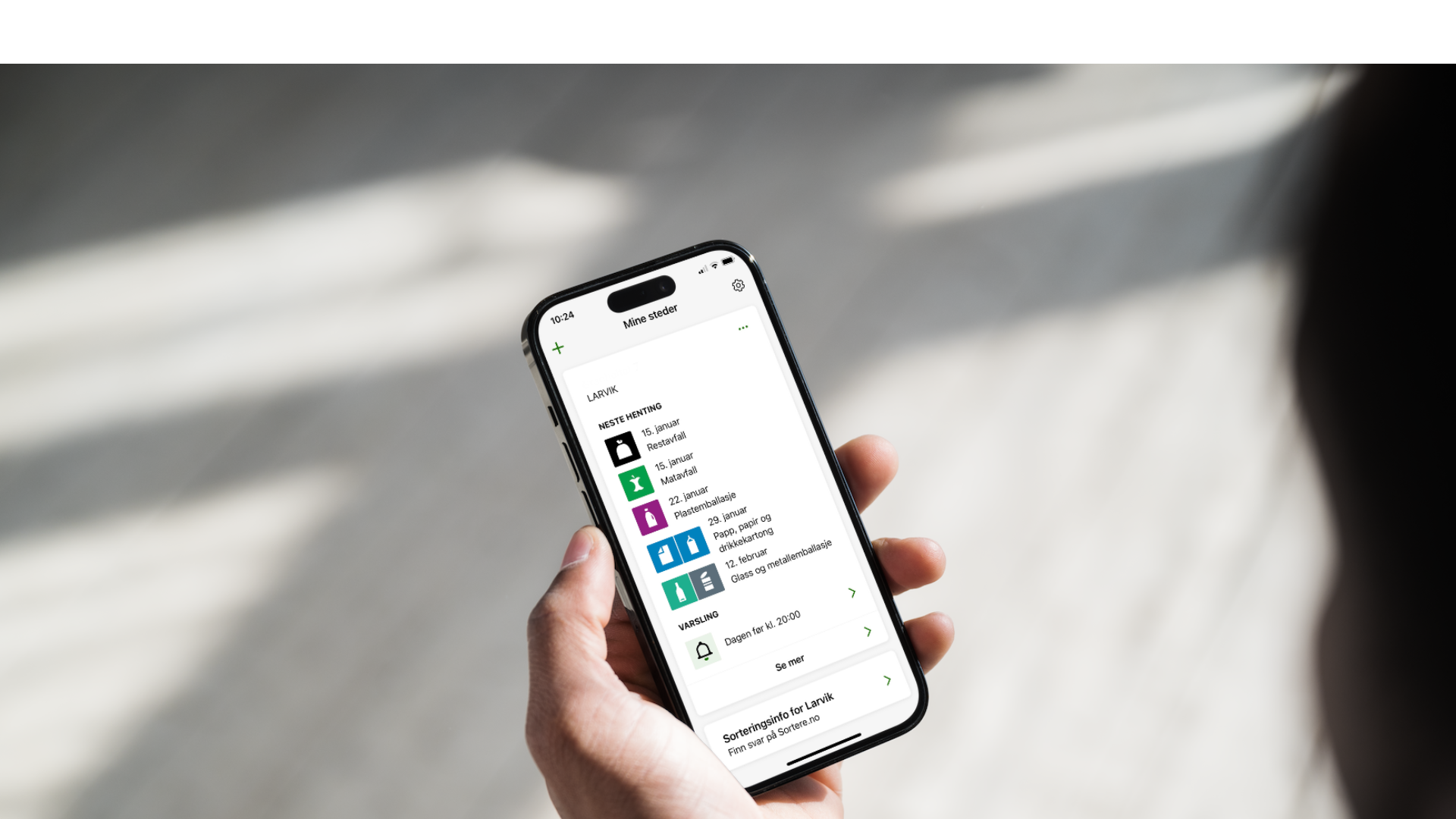 Person som holder mobil med appen MinRenovasjon
