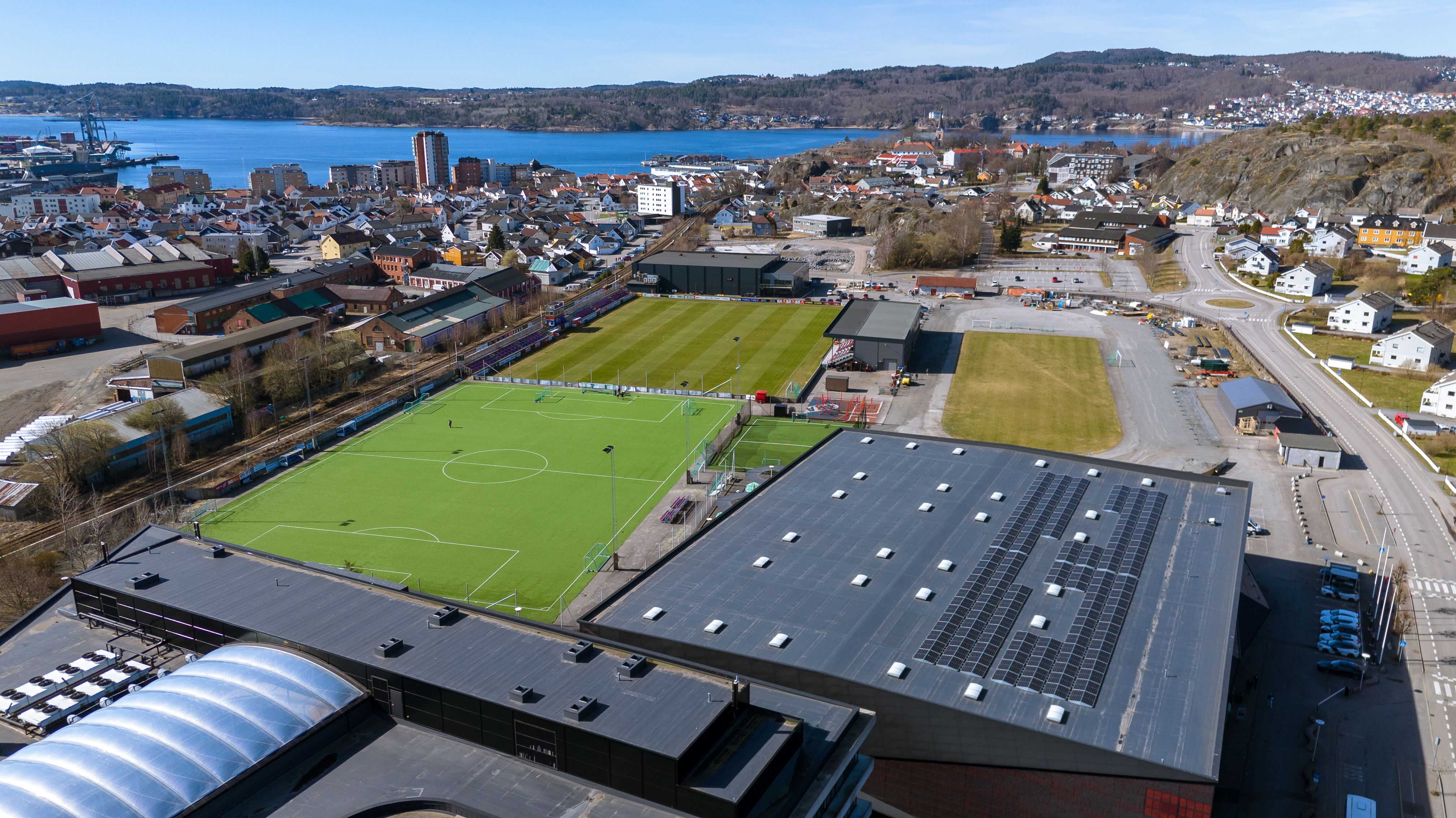 Oversiktsbilde av en idrettshall og fotballbane.