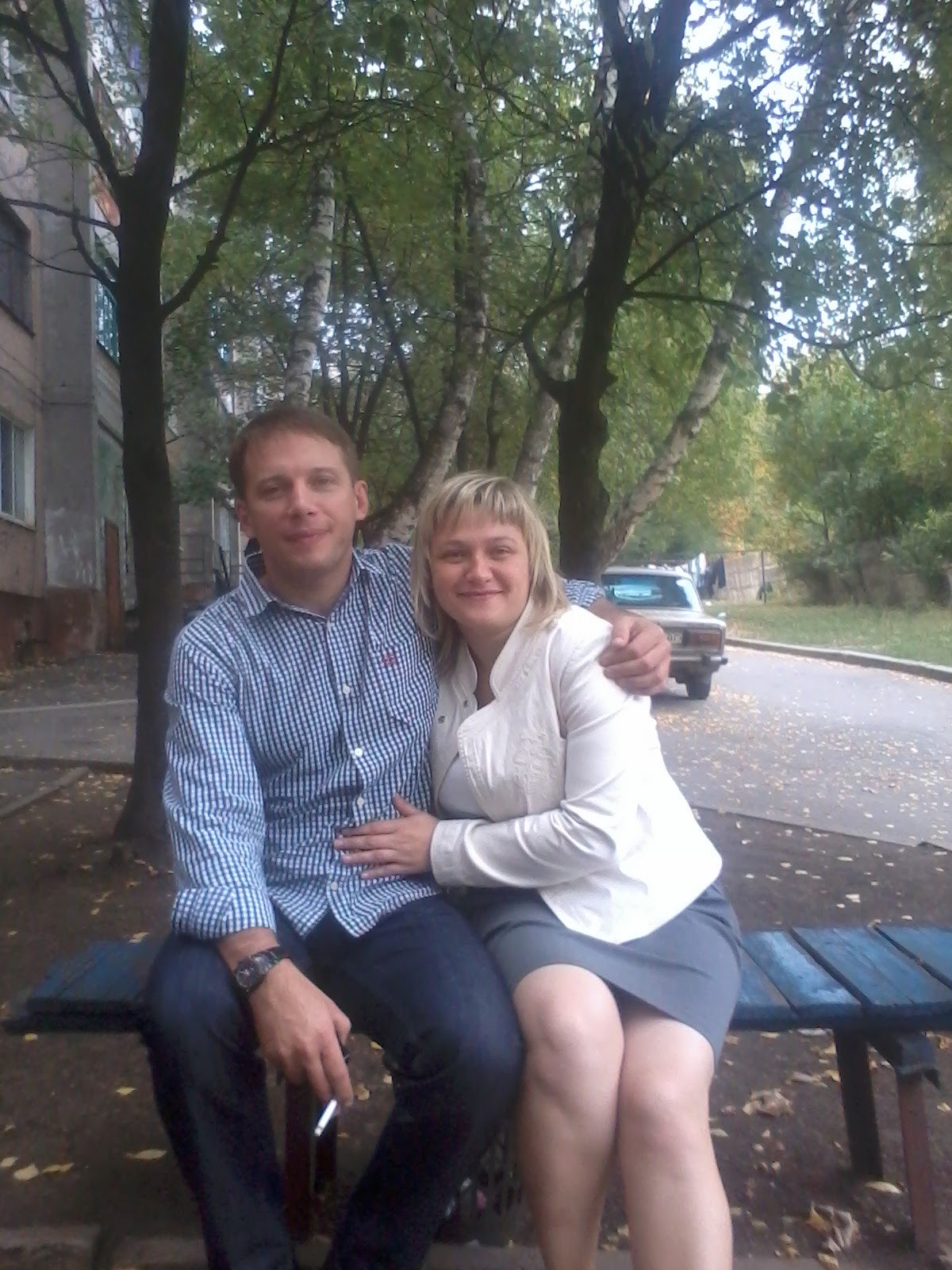 En mann og en kvinne sitter ute i Ukraina, arm i arm.